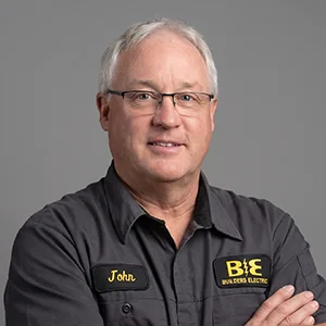 Studio portrait of a Builder's Electric team member in a branded shirt
